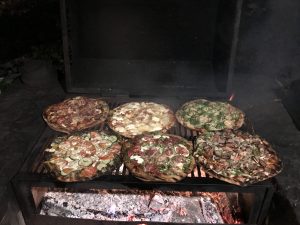 luxury camping, open flame cooking, rustic pizzas